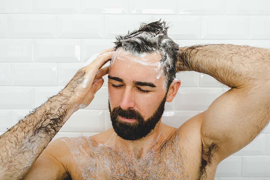 bearded man in shower using Dr. Squatch hair care