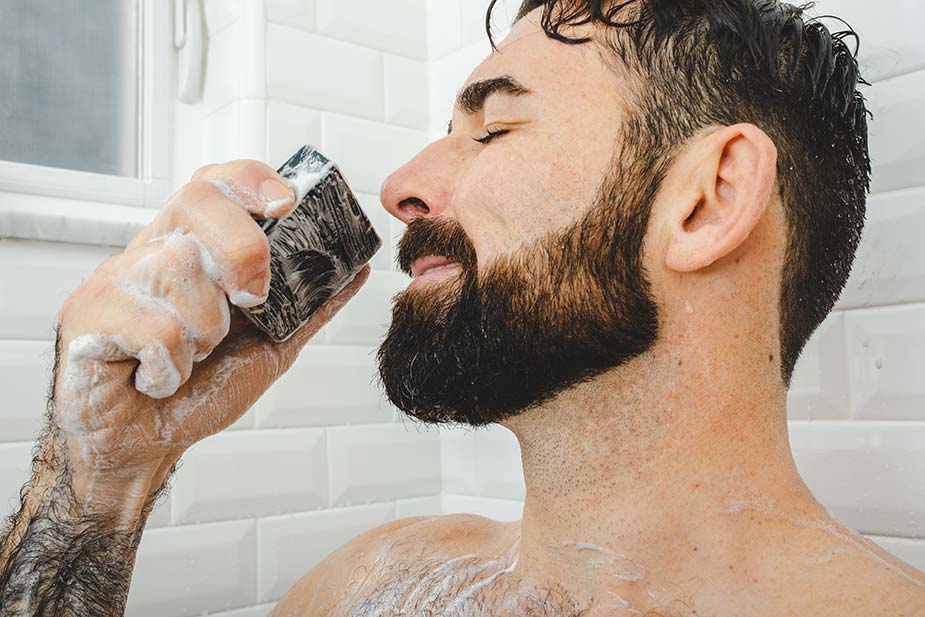 bearded man smelling and savoring Dr. Squatch soap
