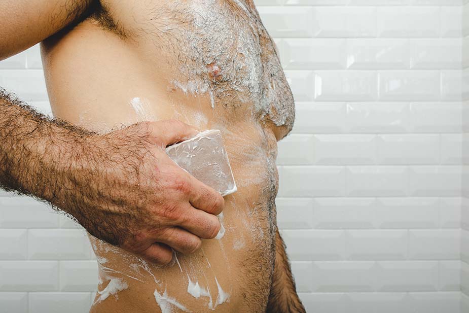 shot of a man's torso in shower using Dr. Squatch soap