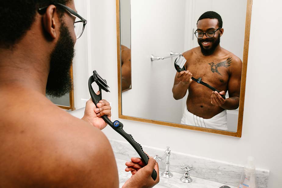 man looking into mirror and smiling while holding his bakblade