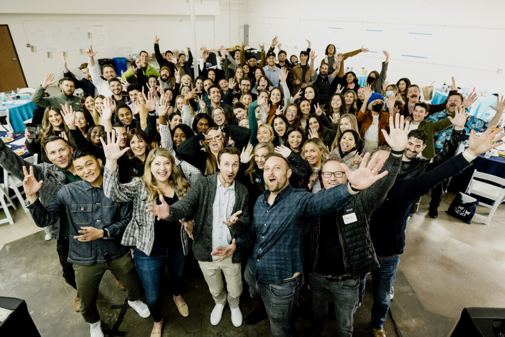 group photo of raindrop employees smiling and cheering